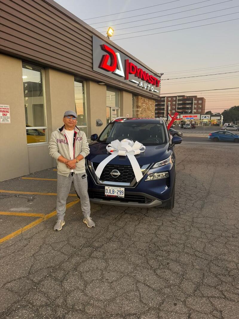 Customer with his new blue Nissan Rogue